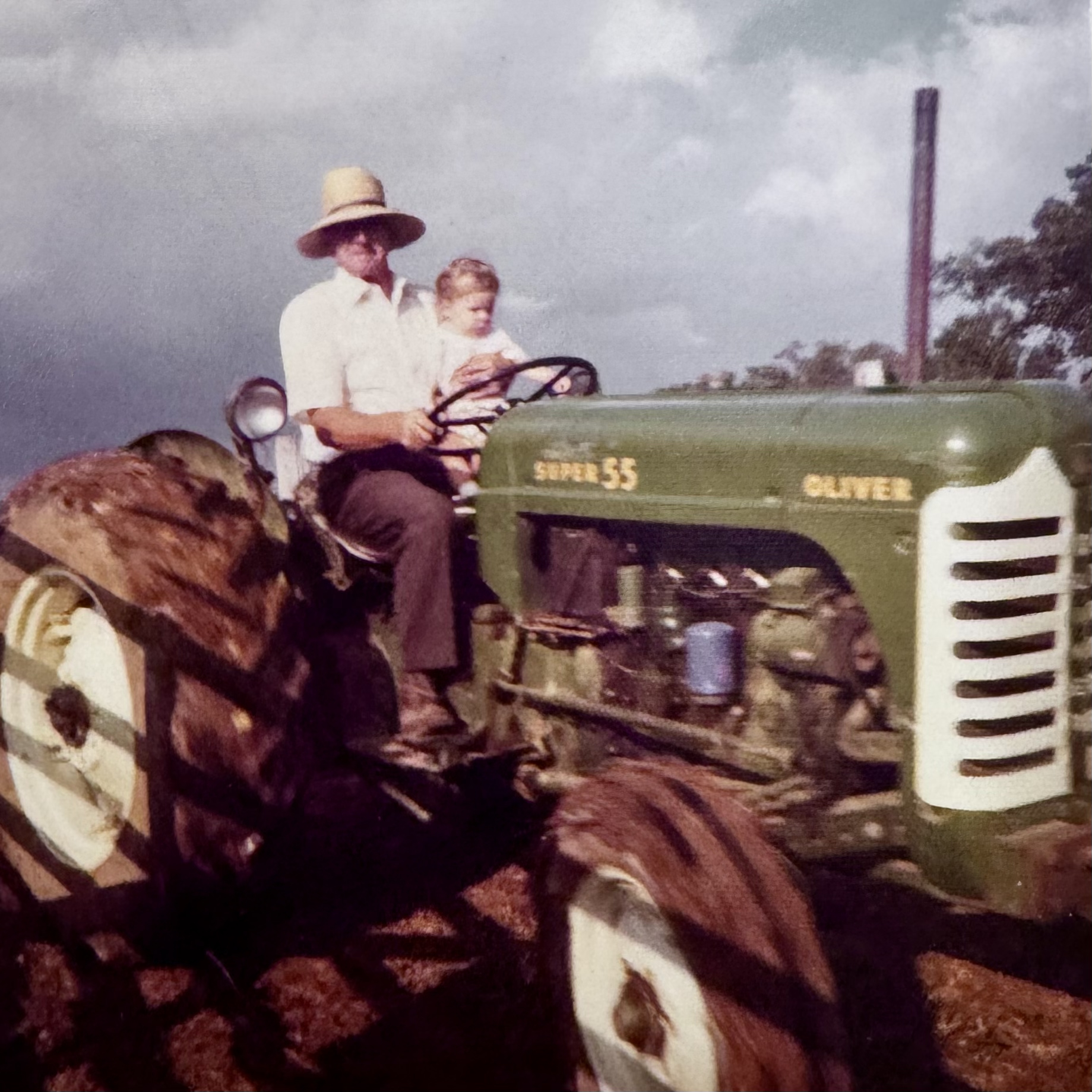 A bundled-up child's first tractor ride on the farm in winter, 1974